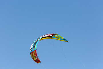 Wing of paraglider on empty blue sky
