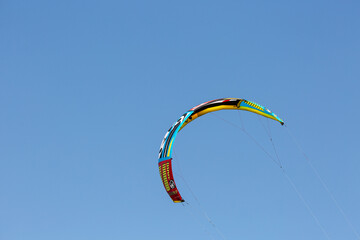 Wing of paraglider on empty blue sky