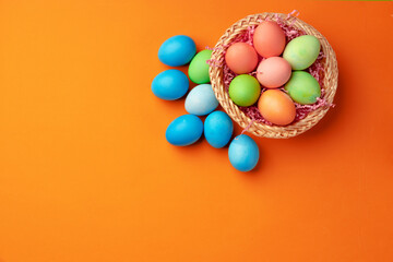 Easter eggs in a nest on orange background