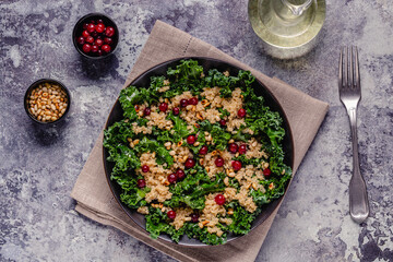 Healthy raw kale and quinoa salad with cranberry and pine nut.