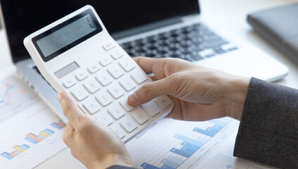 Accounting businesswomen are calculating income-expenditure and analyzing real estate investment data, Dedicated to the progress and growth of the company, Financial and tax systems concept.