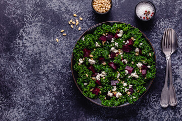 Healthy raw kale and beetroot salad with feta cheese and pine nut.