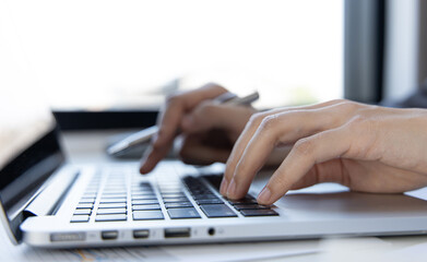 Close-up of a woman's hand pressing on the laptop keyboard,World of technology and internet communication, Financial professionals use laptop to calculate and check real estate earnings.