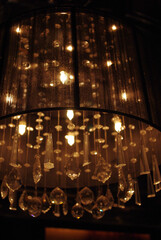 A lot of lamps hanging of the ceiling in a night bar of Seville, Spain. With a statue of buddha