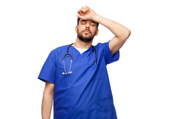 healthcare, profession and medicine concept - tired doctor or male nurse in blue uniform with stethoscope over white background