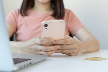 Close-up image of woman's hand holding a phone or smartphone For internet and entertainment or to relax after working in the office, Technology communication and internet networking.