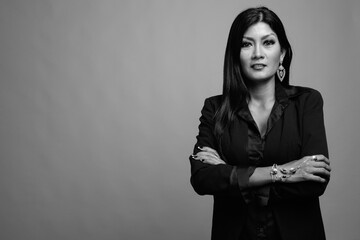 Mature beautiful Asian businesswoman against gray background