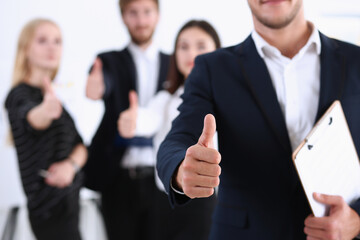 Handsome smiling man showing OK or approval sign with thumb up in creative people office portrait. High level and quality service, job offer, excellent education, advisor, serious business concept