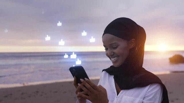 Somali-American woman checking her social media at a beach in Malibut.