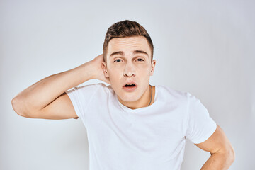 Obraz premium Nice man in a white t-shirt gestures with his hands emotions surprise studio