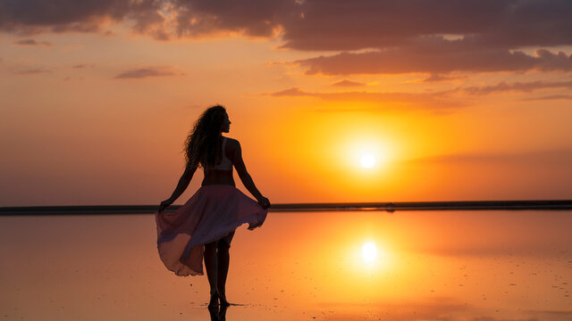 Girl walking towards the goal in the rays of a golden sunset