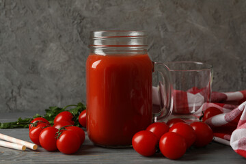 Fototapeta na wymiar Jar of tomato juice, tomatoes and kitchen towel on wooden background