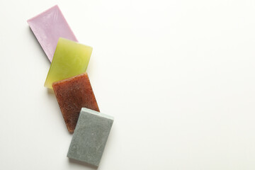 Different pieces of natural soap on white background