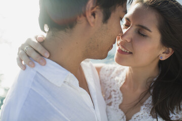 .Beautiful wedding couple bride and groom on yacht at wedding day outdoors in the sea. Happy marriage couple kissing on boat in ocean. Stylish Marine wedding.