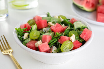 Delicious salad with watermelon served on white table, closeup