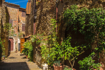 Fototapeta na wymiar A street of historic stone buildings in the village of Montemerano near Manciano in Grosseto province, Tuscany, Italy 