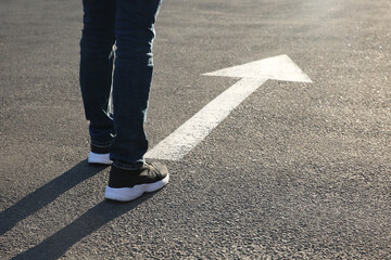 Man going along road with arrow marking, closeup