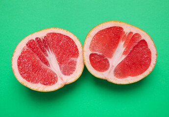 Delicious fresh cut grapefruit on green background, flat lay