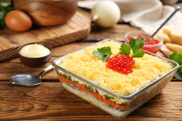 Traditional russian salad Mimosa served on wooden table