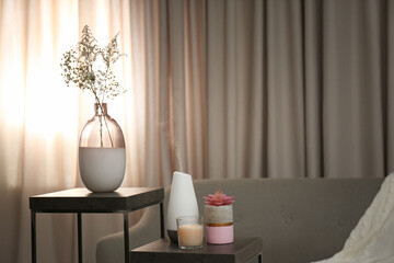 Aroma oil diffuser and candle on table in room