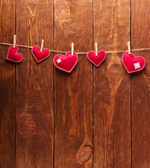 Concert for Valentine's Day. Red hearts made of felt pinned with clothespins to a string against background of boards