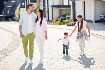 Fototapeta premium Full length body size view of four adorable cheerful dad mom small little kids embracing going outside enjoying sunny day