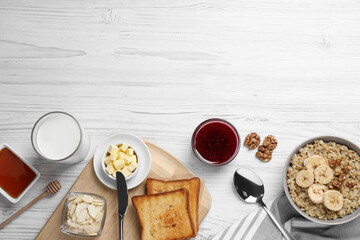 Flat lay composition with tasty breakfast food on white wooden table. Space for text