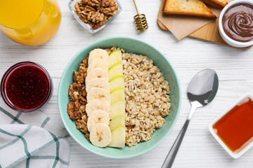 Tasty breakfast with oatmeal porridge on white wooden table, flat lay