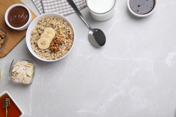 Tasty breakfast with oatmeal porridge on light grey marble table, flat lay. Space for text