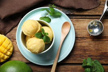 Delicious mango ice cream served on wooden table, flat lay