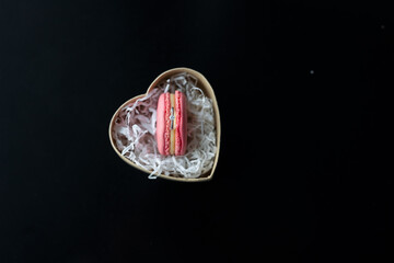 engagement ring with a diamond in a pink macaroni cookie in a box in the shape of a heart