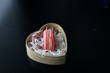 engagement ring with a diamond in a pink macaroni cookie in a box in the shape of a heart