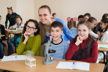 Students using science beakers and a microscope at the elementary school