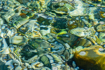 Fototapeta na wymiar Texture of pebbles under water at the seaside. Natural background