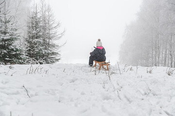 Fototapeta na wymiar Kind rodeln im Schnee im Winter