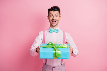 Photo portrait of cheerful guy receiving present isolated on pastel pink colored background