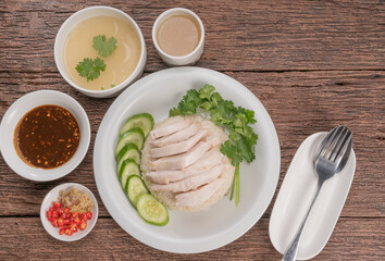 Hainanese chicken rice on a white table background, Steamed chicken rice with spicy sauces and chicken soup,