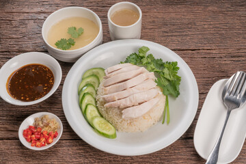 Hainanese chicken rice on a white table background, Steamed chicken rice with spicy sauces and chicken soup,