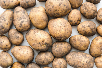 potatoes on white background, dirty potatoes, a bunch of potatoes