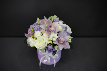 Fresh flowers are collected in a bouquet. A hatbox with flowers in lilac color.
