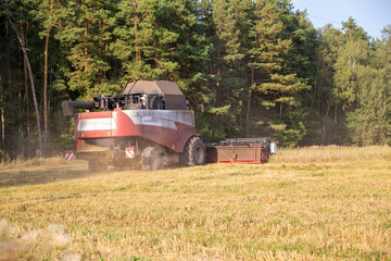 old combine harvester harvests from the field