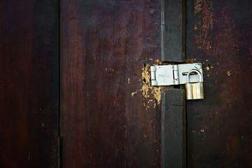 Old golden padlock locked old wood brown door. Home security.