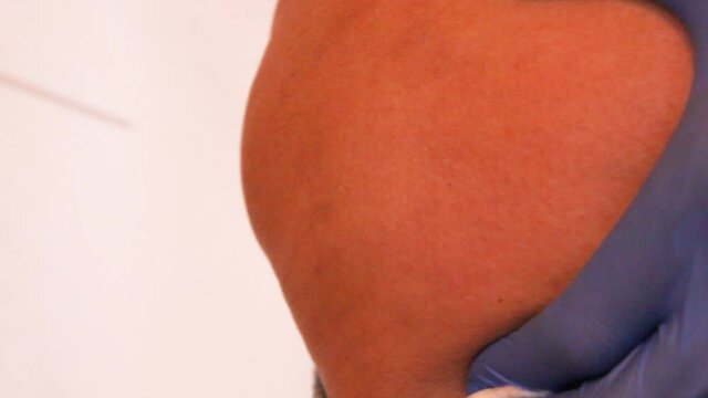 Injection with a syringe in the buttock, ass, in the back, in the muscle, vaccine, injecting vitamins into the blood