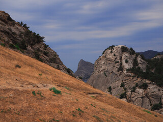 Landscape of stone mountains on a summer day. Variegated bright colors: blue, sandy, green. Stones in their natural environment.