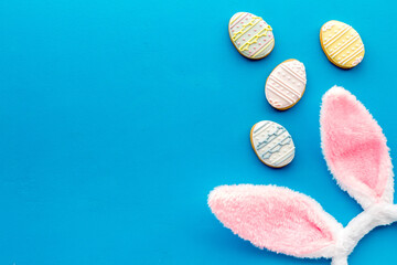 Top view of Easter bunny ears with eggs cookies, space for text