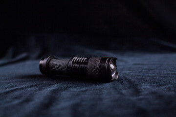 tactical flashlight on a black background shines