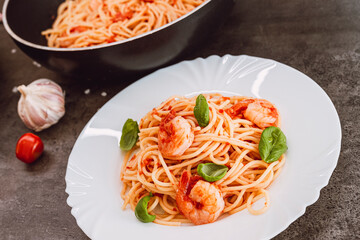 Spaghetti with tomato sauce, basil and shrimps. Italian cuisine. Fresh healthy light main course, serving on a plate