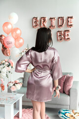 Bride in a silk robe at a bachelorette party.