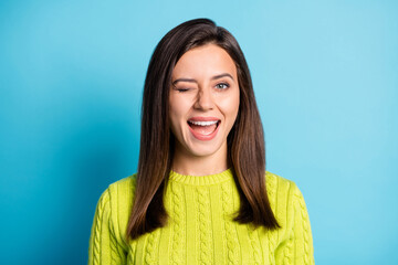 Fototapeta premium Portrait of young beautiful smiling positive happy girl woman female wink eye on camera isolated on blue color background