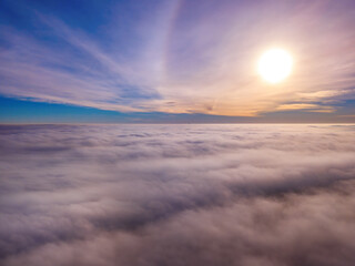 Naklejka na ściany i meble Aerial photo above the fog or white clouds with shining sun. Beautiful sunrise cloudy sky from aerial view. Above clouds from airplane window or drone.